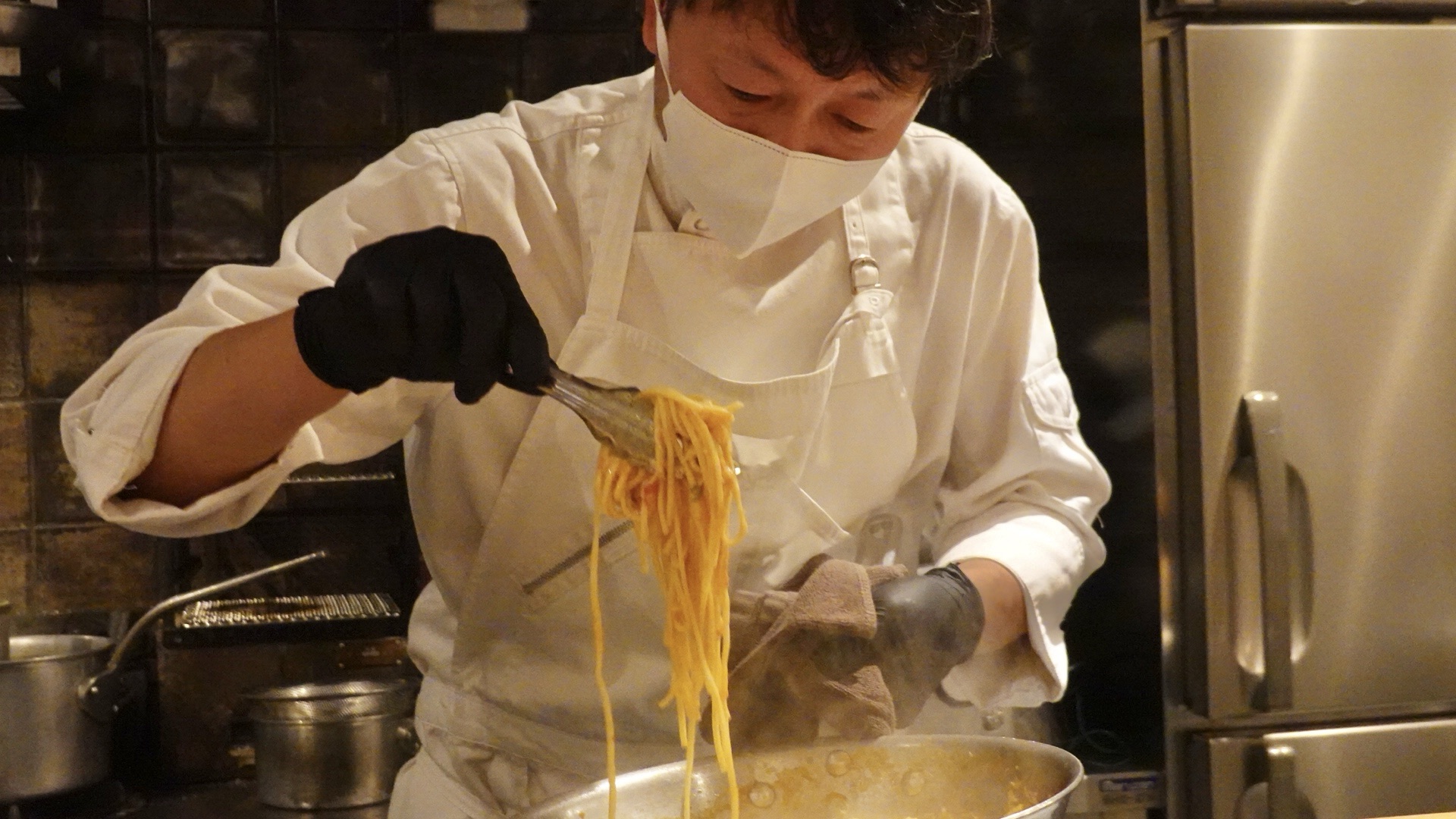 木場 commedia シェフがパスタを盛り付けている